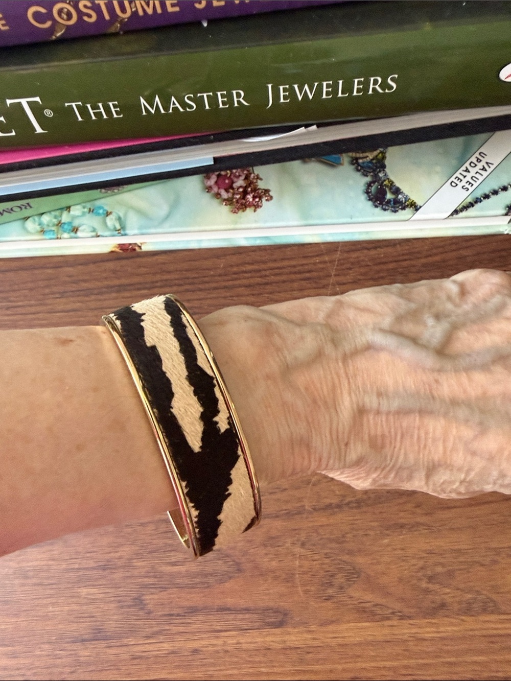 Bangle Bracelet w/Faux Zebra Printed Hide Set in a Gold Tone Elliptical Frame.